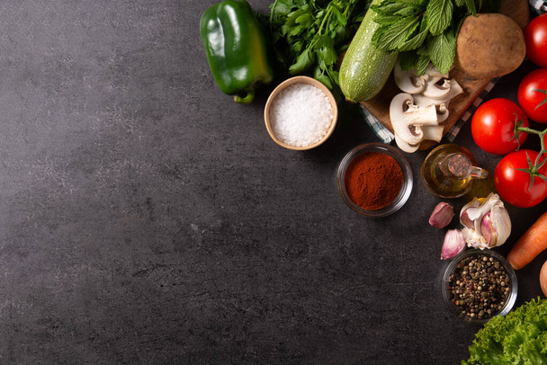 Assortment of vegetables, herbs and spices on black background. Top view. Copy space - Фото, зображення