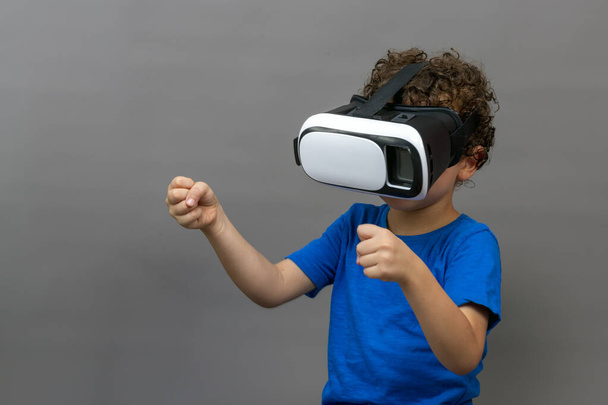 close-up of freckled, curly-haired boy playing with virtual reality goggles - Foto, imagen