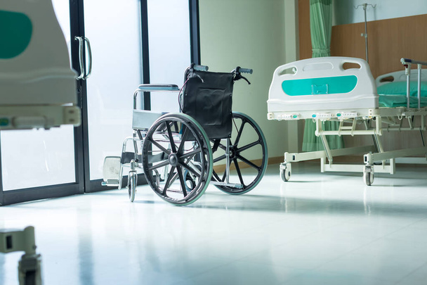 Empty wheelchair parked in Patient Rooms at hospital. The wheelchair patient is in the hospital ward.  - Photo, image