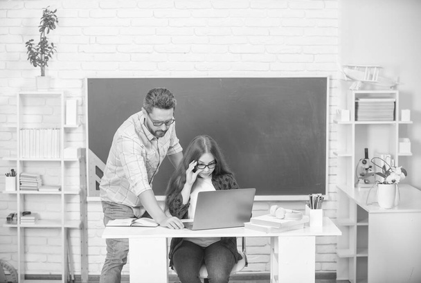 curious father and child study at school with laptop on blackboard background, back to school - Photo, Image