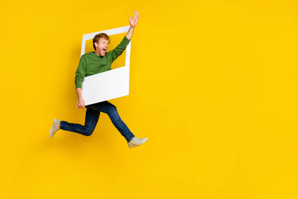 Full length photo of impressed pretty man wear pullover tacking photo waving arm empty space isolated yellow color background - Foto, imagen