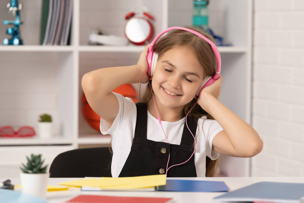 positiivinen lapsi kuunnella musiikkia kuulokkeet koululuokassa - Valokuva, kuva