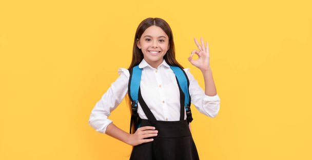 concept of education. kid with long hair in uniform on yellow background. september 1. - Photo, Image