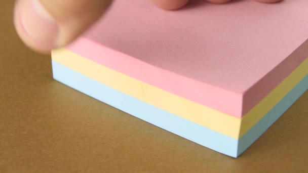 Post it super sticky notes Colors pastel stick remember reminderGetting ready to begin work business. Finger leafing through scrolling examining a ream of empty post-it notes multicolored sticky. Ready to organize. - Footage, Video
