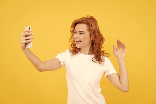 Image of excited happy young woman isolated overyellow background make selfie by camera. - 写真・画像