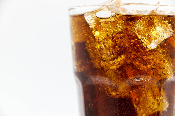 Cola üveg zúzott egy fehér háttér kóla jég üveg, és vannak vízcseppek körül. hűvös fekete friss ital.  - Fotó, kép