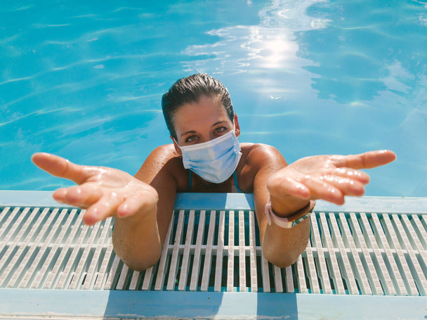 Young cheerful woman wearing face mask against Covid 19 during summer vacation under pandemic. - Foto, immagini