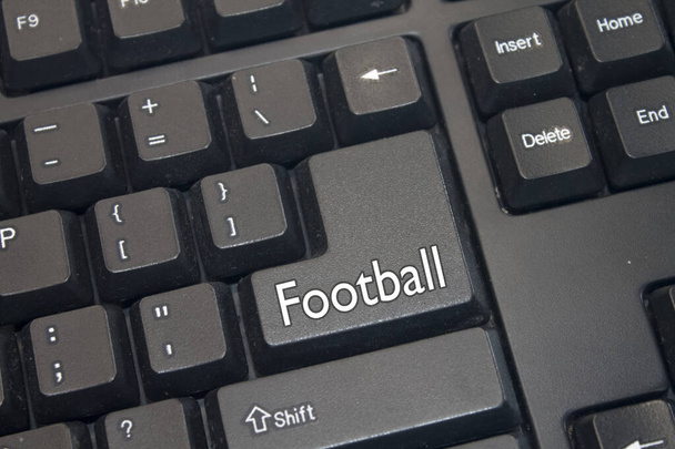 Teclado de ordenador negro con texto de fútbol. Primer plano de una parte electrónica del dispositivo informático, teclado. - Foto, imagen