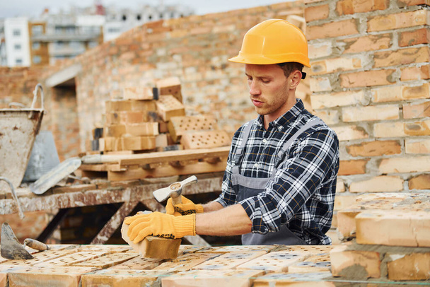Laying bricks. Construction worker in uniform and safety equipment have job on building. - Φωτογραφία, εικόνα