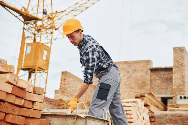 Construction worker in uniform and safety equipment have job on building. - Φωτογραφία, εικόνα