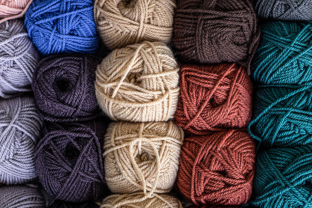 Boules colorées de laine sur table en bois. Variété de boules de fil, vue d'en haut. - Photo, image