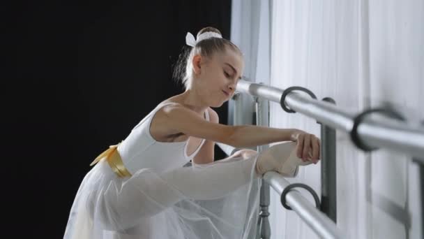 Motiviertes starkes, flexibles Teenager-Mädchen, das sich mit Ballettbarre dehnt. Weibliche Kindertänzerin Ballerina im Tutu Kaukasische Kindermädchen dehnen Beinmuskeln Anstrengung choreographische Übung in der Tanzschulklasse - Filmmaterial, Video