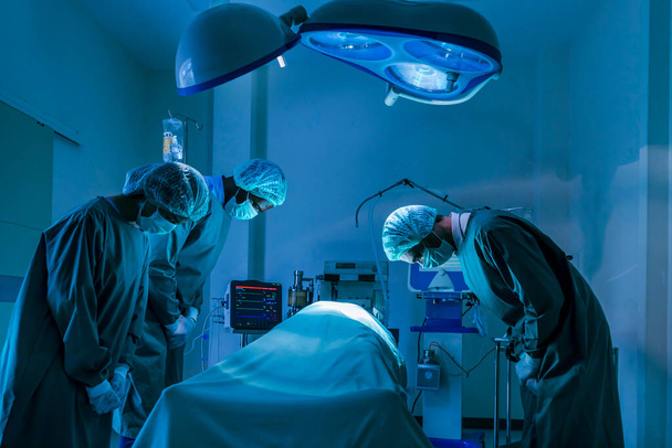 Een team van chirurgen brengt respect en hulde aan de orgaandonor na zijn dood aan een ongeneeslijke ziekte om meer levens te redden in de spoedeisende chirurgische ruimte. - Foto, afbeelding