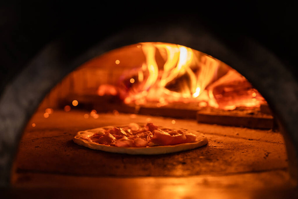 Pizza uuni palaa liekeissä saada valmis leipoa pizzaa - Valokuva, kuva