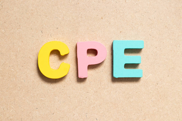 Väri kirjain sanalla CPE (lyhenne täydennyskoulutuksesta, asiakkaan toimitilojen laitteista tai kustannuksista sitoutumista kohti) puupohjalla - Valokuva, kuva