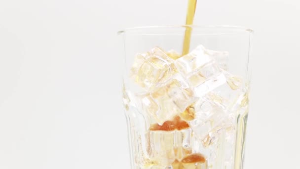 Cola gieten met ijsblokjes van dichtbij. Cola met ijs in glas. Coke Soda close-up. Draaien glas van Cola drinken over witte achtergrond. - Video