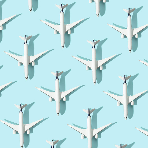 Creative composition made with passenger plane on blue background. Summer travel or vacation pattern. - Foto, imagen