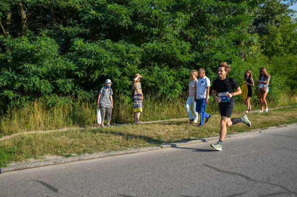 KYIV, UKRAINE - JULY 24, 2021: Group of runners jogging outdoors. Sportive people competing in a urban area, healthy lifestyle and sport concepts. - Фото, зображення