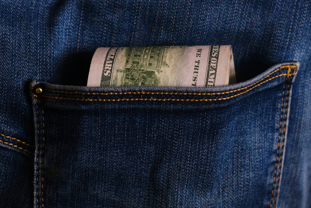Jeans pocket with money, close-up. Blue jeans pocket with hundred dollars banknotes - Фото, изображение