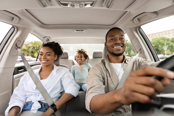 Fröhliche afroamerikanische Familie im Urlaub mit neuem Auto unterwegs - Foto, Bild