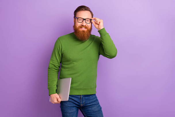 Photo of handsome positive young experienced freelancer man with netbook isolated on violet color background - Foto, afbeelding