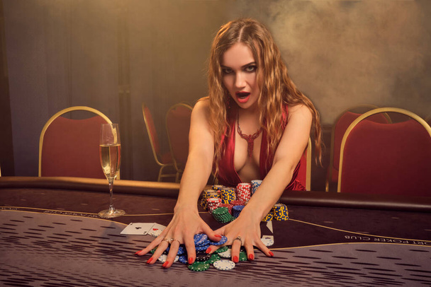 Γοητευτική γυναίκα με όμορφο χτένισμα και τέλειο μακιγιάζ παίζει πόκερ. Καζίνο. - Φωτογραφία, εικόνα