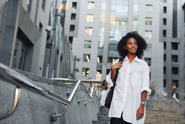 Африканская американка в хорошей одежде находится на улице в городе днем. - Фото, изображение