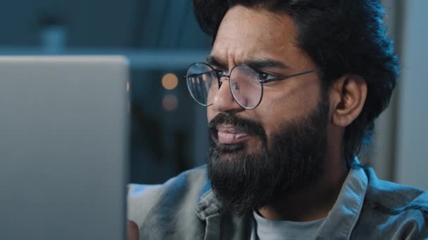 Lähikuva Arabian Intian parrakas 30s mies freelancer käyttäjä käyttää silmälaseja katsomalla tietokoneen näytön yöllä kotona on ongelmia yhteyden haku vaikeuksia online-selailu ajattelu kirjoittamalla - Materiaali, video