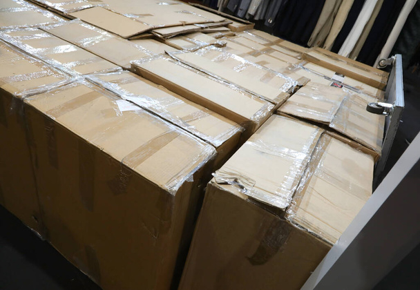 entrepôt avec de nombreuses boîtes en carton ondulé fermé avec du ruban adhésif pendant l'évacuation - Photo, image