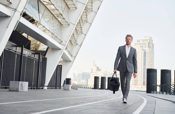 Urban beauty. Young businessman in grey formal wear is outdoors in the city. - Fotografie, Obrázek