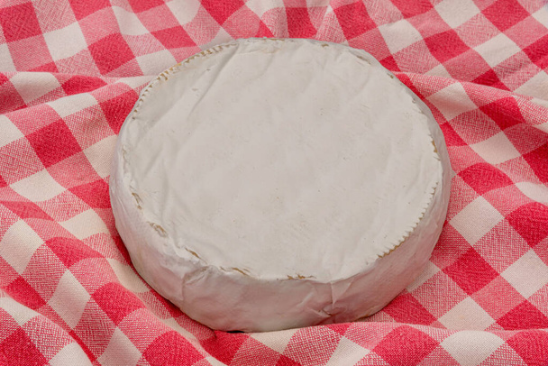 Rueda de queso crema Brie en un mantel a cuadros rojo - Foto, Imagen