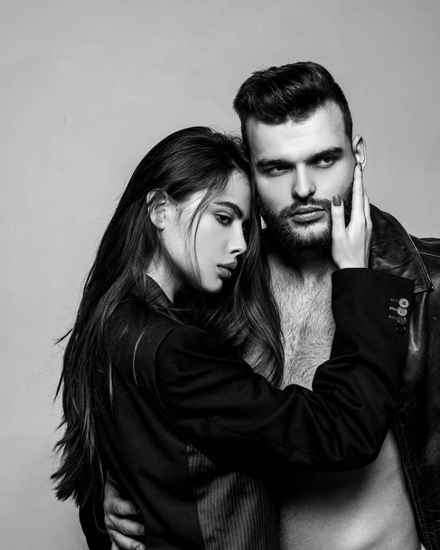 Man brutal well groomed macho and attractive feminine girl long hair cuddling. Girlfriend passionate red lips and man leather jacket. Passionate hug. Couple passionate people in love. Passion fashion - Photo, Image