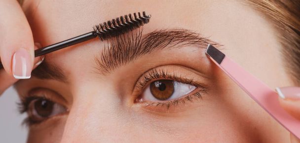 Woman on the brow beauty procedures. Care for brows, eyebrows lamination. Macro close up of brows. - Fotografie, Obrázek