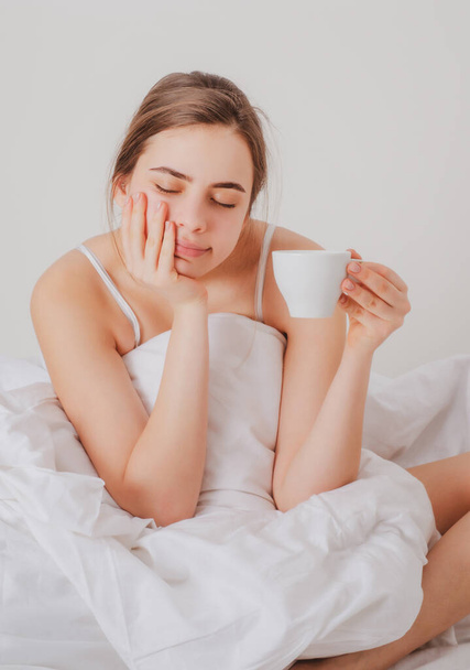 Woman with morning coffee on the bed. - Фото, зображення