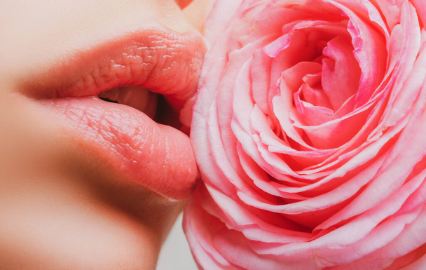 Young girl with beautiful nude make-up and plump lips. Perfect natural lips close up. Beautiful woman lips with rose. - Foto, imagen
