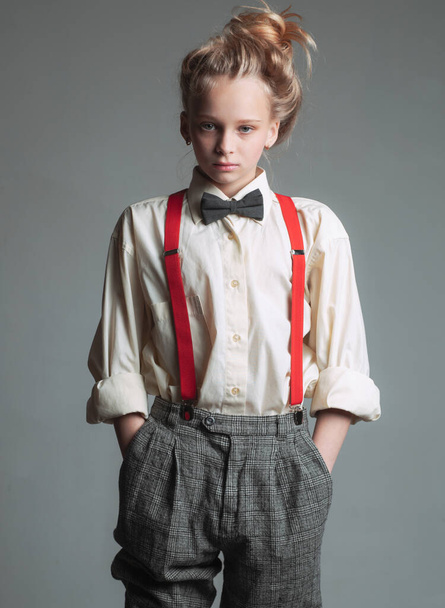 Funky style. suspender and bow tie. old fashioned child. vintage english style. retro fashion model. vintage charleston party. jazz step fashion. teen girl in retro male suit. Cool and trendy - Фото, изображение