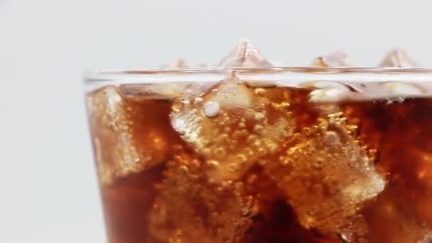 Cola met ijs in glas. Coke Soda close-up. Draaien glas van Cola drinken over witte achtergrond. - Video