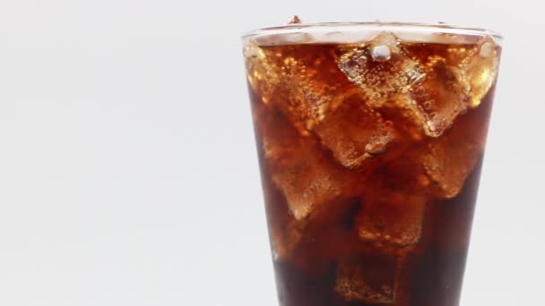 Cola com gelo em vidro. Closeup de refrigerante de coca. Girar vidro de bebida Cola sobre fundo branco. - Filmagem, Vídeo