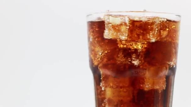 Cola com gelo em vidro. Closeup de refrigerante de coca. Girar vidro de bebida Cola sobre fundo branco. - Filmagem, Vídeo
