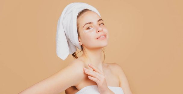 Woman with a facial mask. Charming pretty model after bath wrapped in towel applying using face mask, sensual girl face. - Φωτογραφία, εικόνα