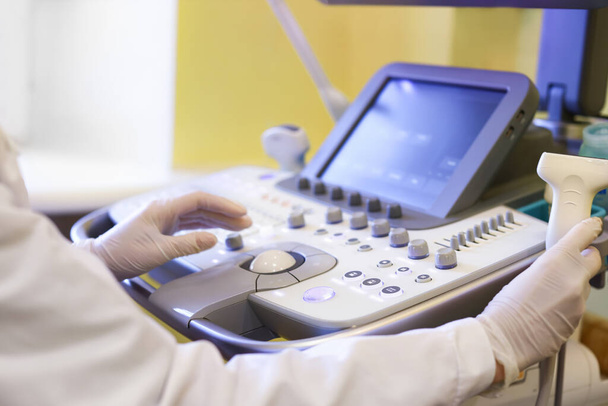 Doctor using ultrasound machine in clinic - Foto, Imagen