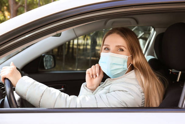 Female driver wearing medical mask in car - Fotoğraf, Görsel