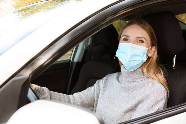 Autofahrerin trägt medizinische Maske im Auto - Foto, Bild