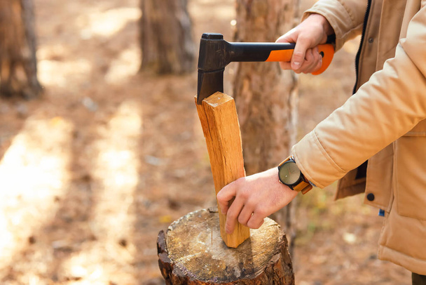 Male tourist chopping wood in forest, closeup - Photo, Image