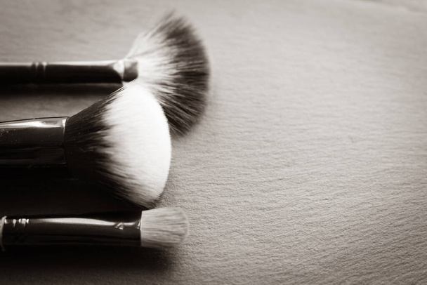 Makeup brush on black background with copy space. Beauty tools. Eye shadow brush. Cosmetics background. Beauty and fashion. Beauty device. Professional make up set.  - Photo, Image