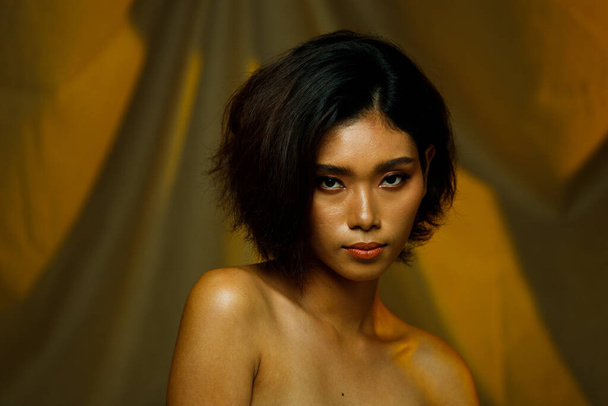 Half body 20s Asian Indian woman tanned skin curl hair beauty skin. Female express feeling smooth silk smile happy over brown canvas drape with lighting background  - Foto, Imagem