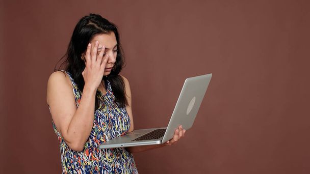 Розчарована людина, яка використовує технології на ноутбуці для прокрутки веб-сайту
 - Фото, зображення