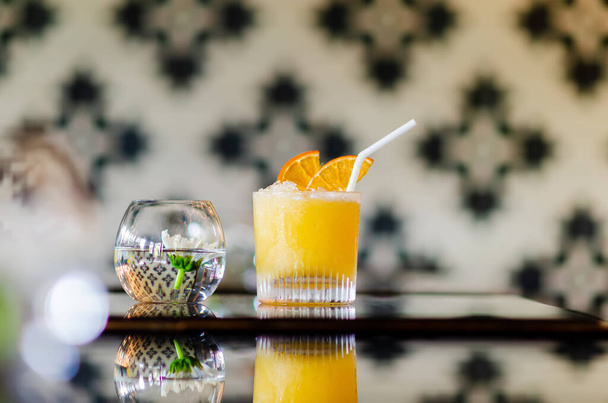 Tatil ve yaz içkisi konsepti için barın masasına bir bardak portakal kokteyli.. - Fotoğraf, Görsel