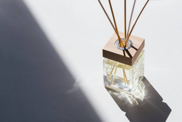 Transparent bottle of aroma diffuser on white background. Eau de parfume for home presentation. Trending concept in natural colors - Valokuva, kuva