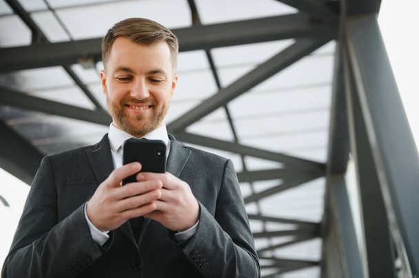 Portrait of a smiling businessman in a modern business environment. - Фото, зображення